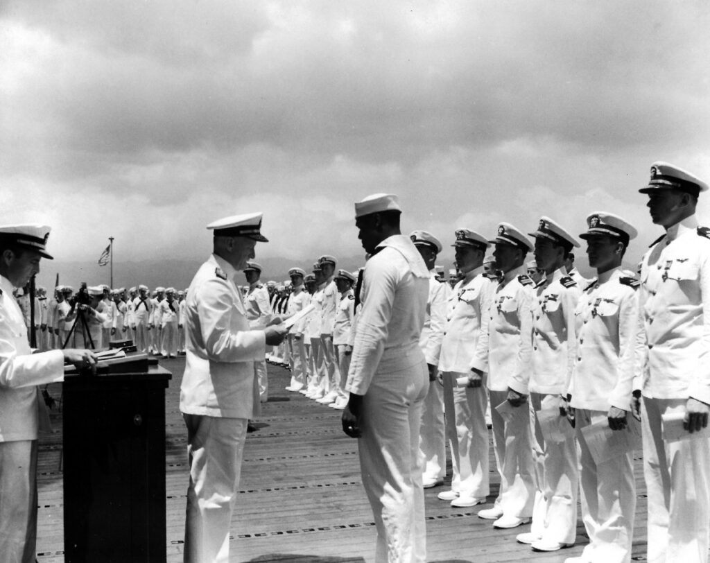 Admiral Chester Nimitz reading Doris Miller's Navy Cross citation at the ceremony of 27 May 1942, with the ship's officers and crew assembled